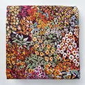Stoff mit buntem Millefleurs-Blumenmuster auf dunklem Grund für Trachten